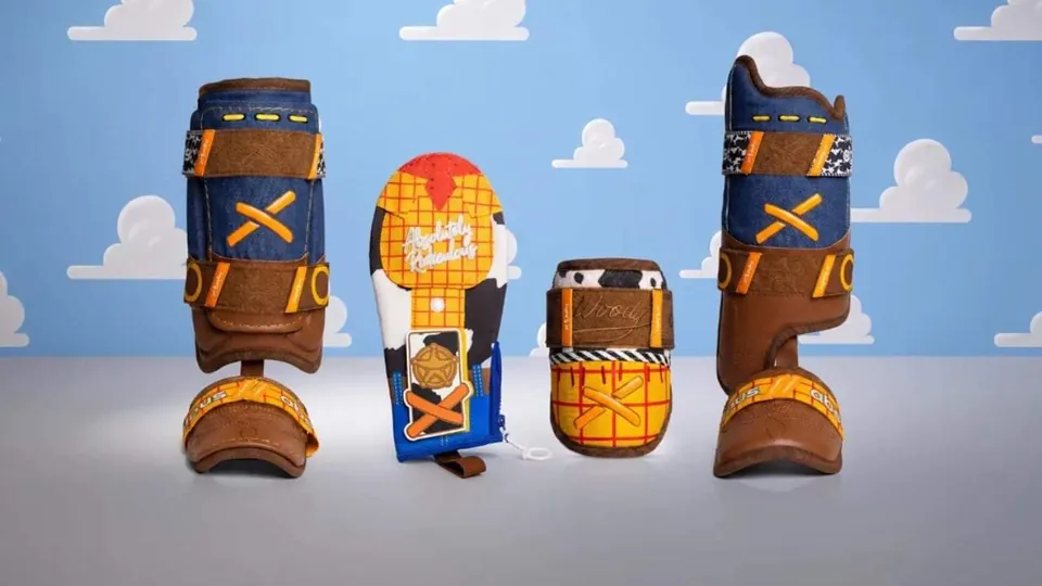 Absolutely Ridiculous × Toy Story Woody collection — leg guards, sliding mitt and elbow guard against Andy’s cloud wallpaper